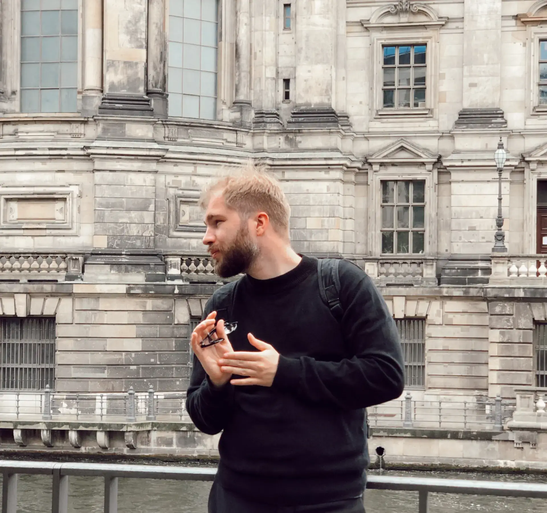 Photo of Dima Groshev standing in the street, wearing a black sweater.